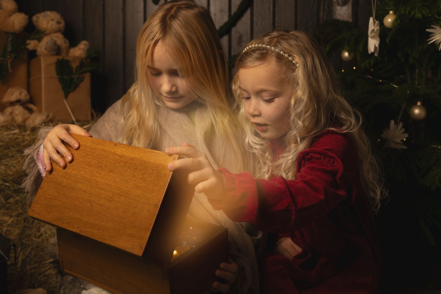 Cozy Christmas scene with candlelight and decorated tree in the background.