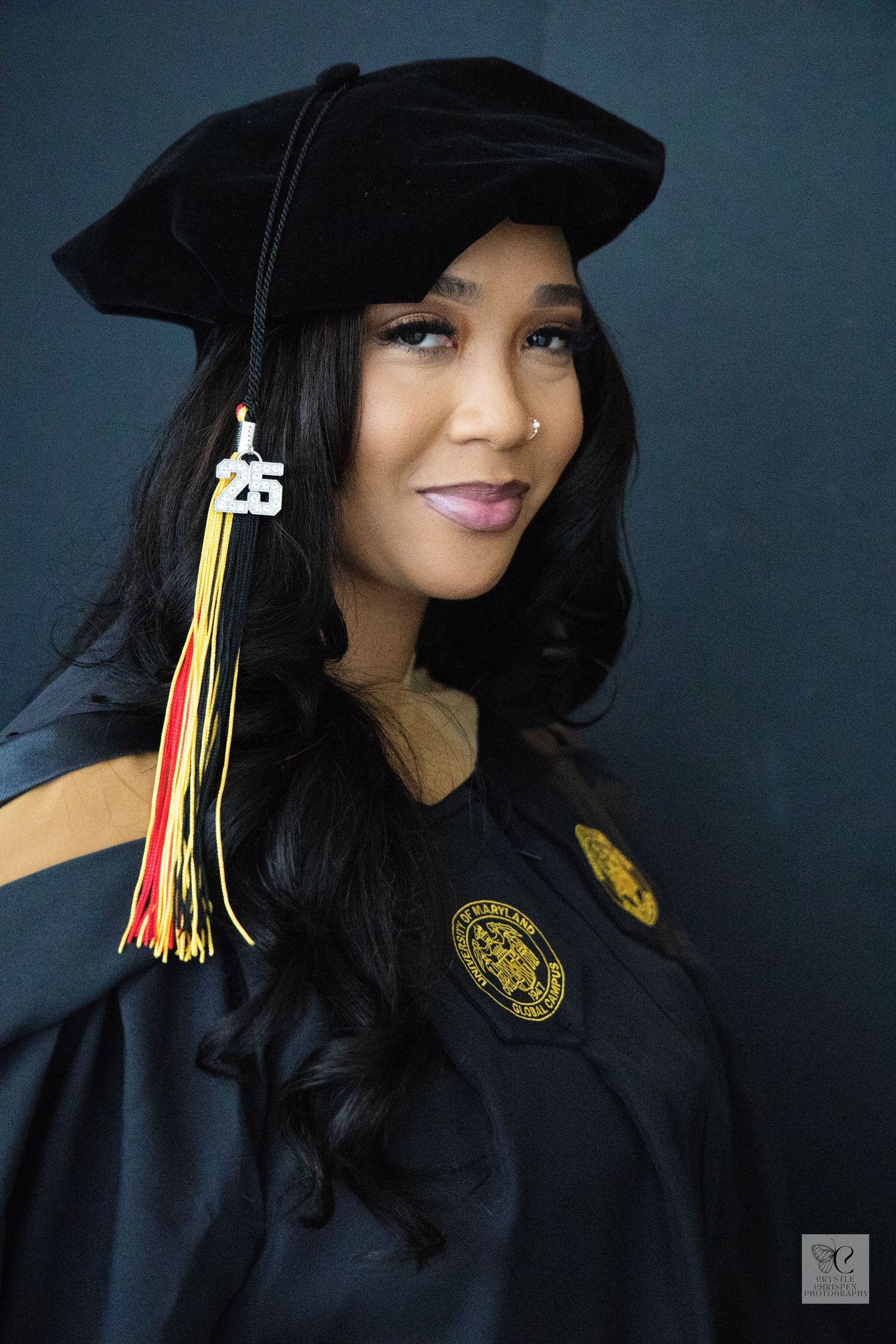 An academic portrait in graduation attire with a black cap and colorful tassel.