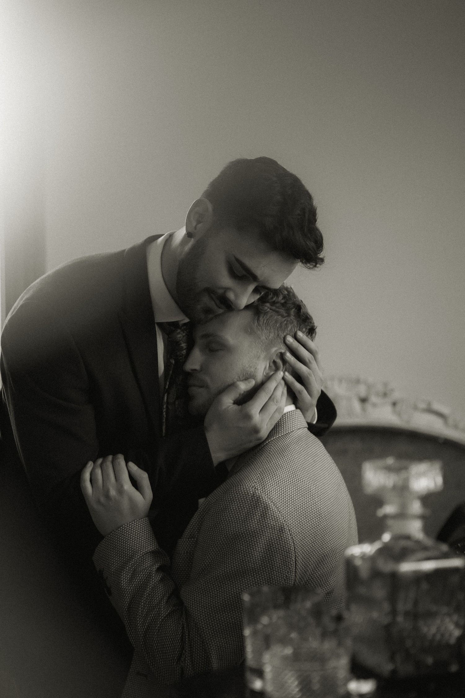 Romantic black and white portrait of couple embracing in formal attire.