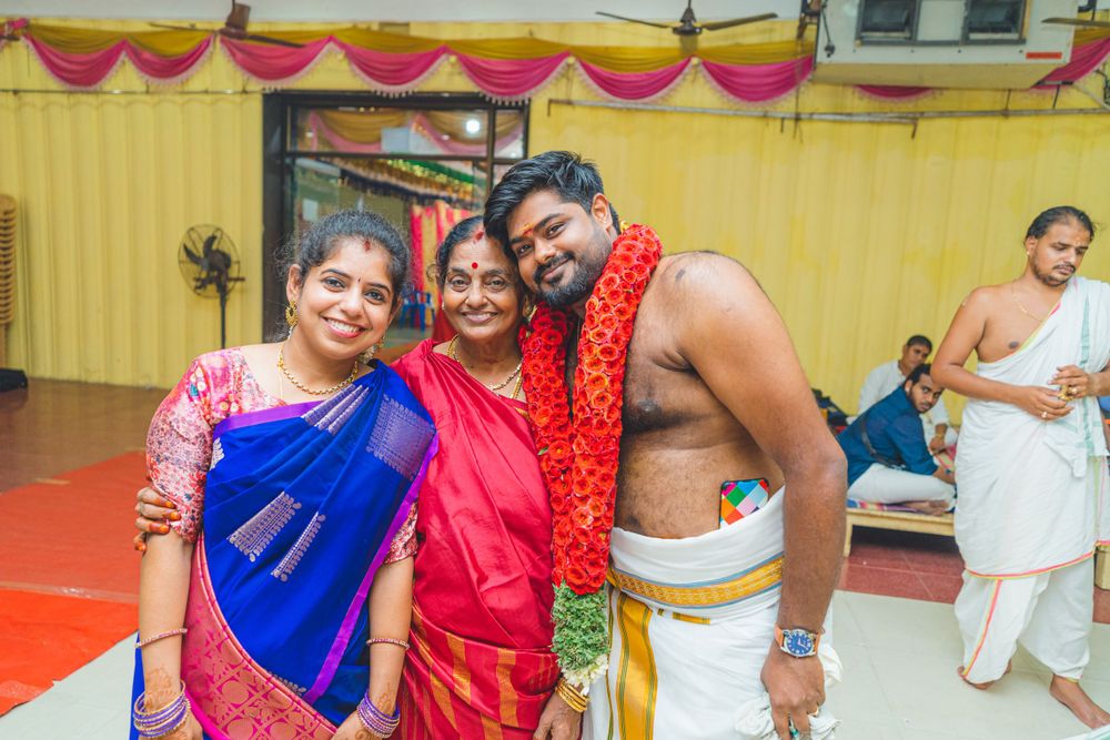 Festive gathering at Indian ceremony with participants wearing traditional clothing and garlands.