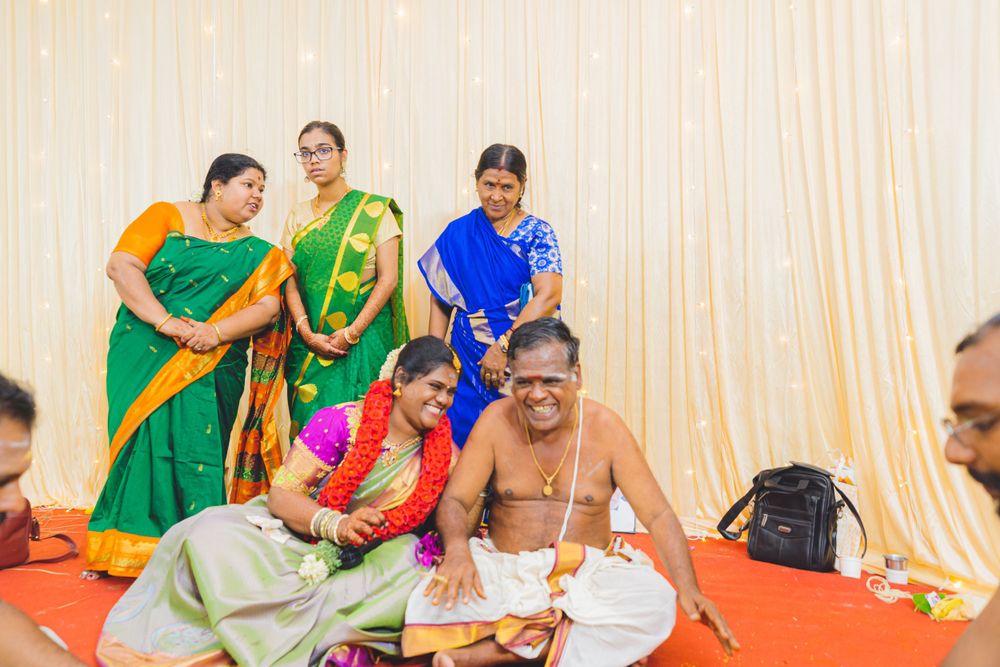 Traditional Hindu ceremony showing participants in colorful saris performing rituals.