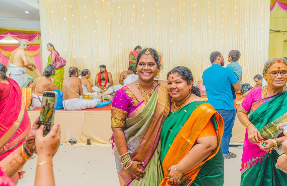 Guests in colorful traditional sarees pose during a festive celebration.