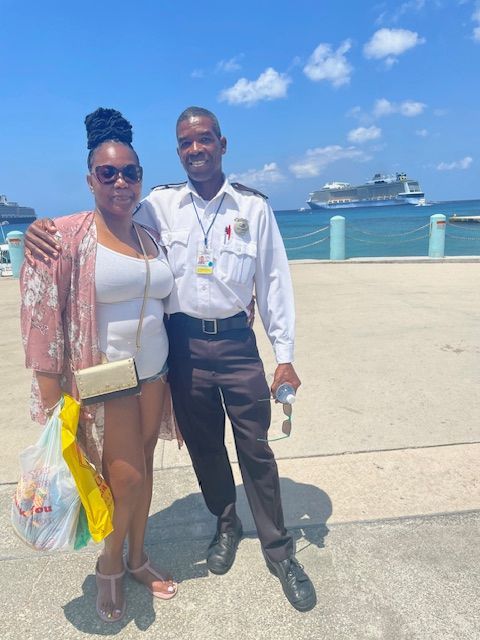 A beachside scene with a cruise ship visible in the background on a sunny day.