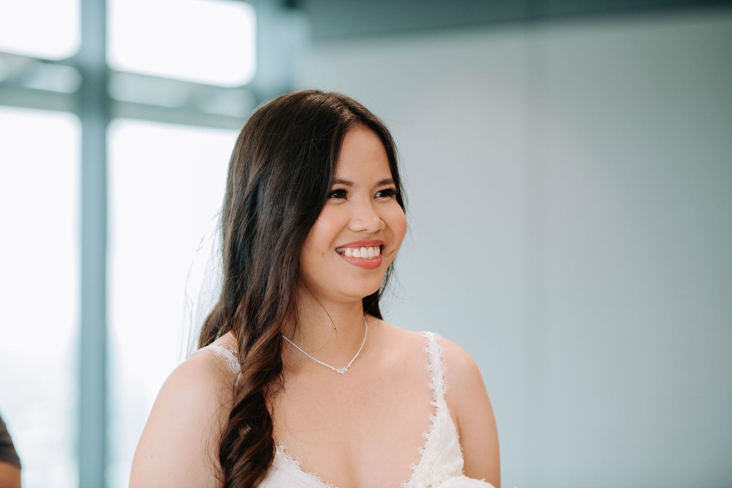 Candid moment during a wedding celebration with natural window lighting.