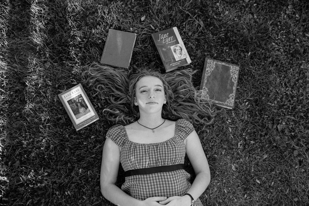 A collection of black and white portraits showing someone resting on grass with scattered photographs.