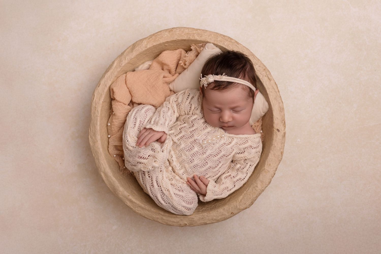 Sweet newborn baby peacefully sleeping during a professional photoshoot