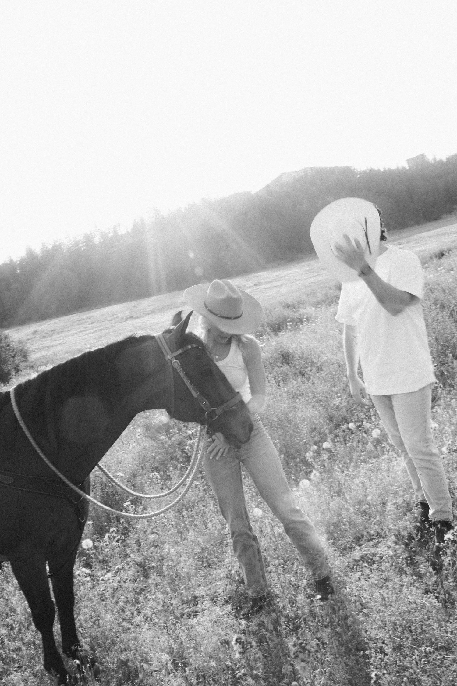 Intimate portrait of a couple in white sweaters sharing a tender moment in golden light.