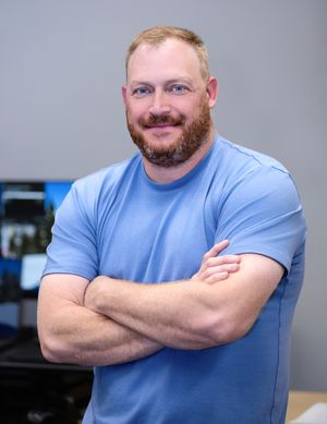 A person in a light blue t-shirt stands with crossed arms against a gray background in a series of similar poses.