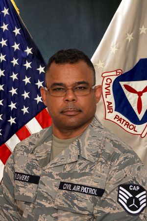 Official military portrait with service member in digital camouflage against American and CAP flags.