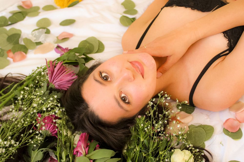 Intimate floral boudoir portraits in OKC with cinematic natural light. Close up headshot of brunette.