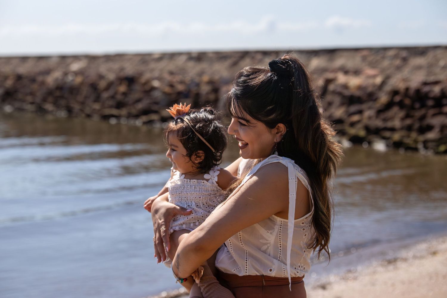 A sweet moment captured between family members on a rocky beach.