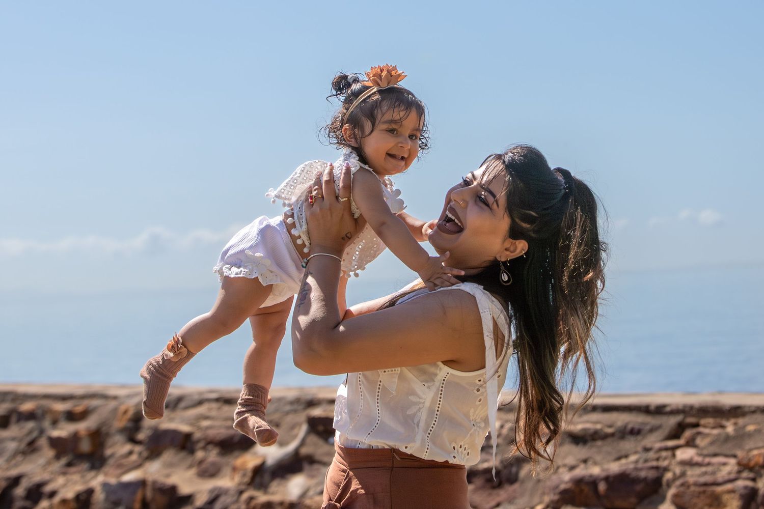 Dynamic family moments photographed on rocky coastal terrain.