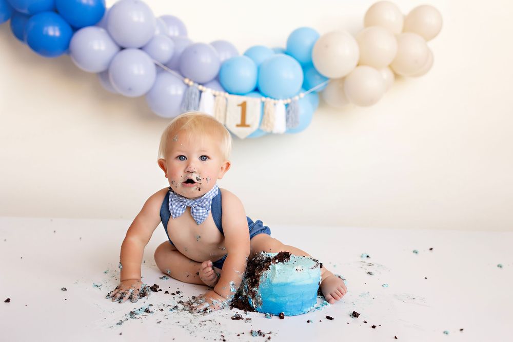 Baby in blue and white cake smash photo session with balloon garland backdrop and smashed cake.  Kendall Kuss Photography Watertown WI