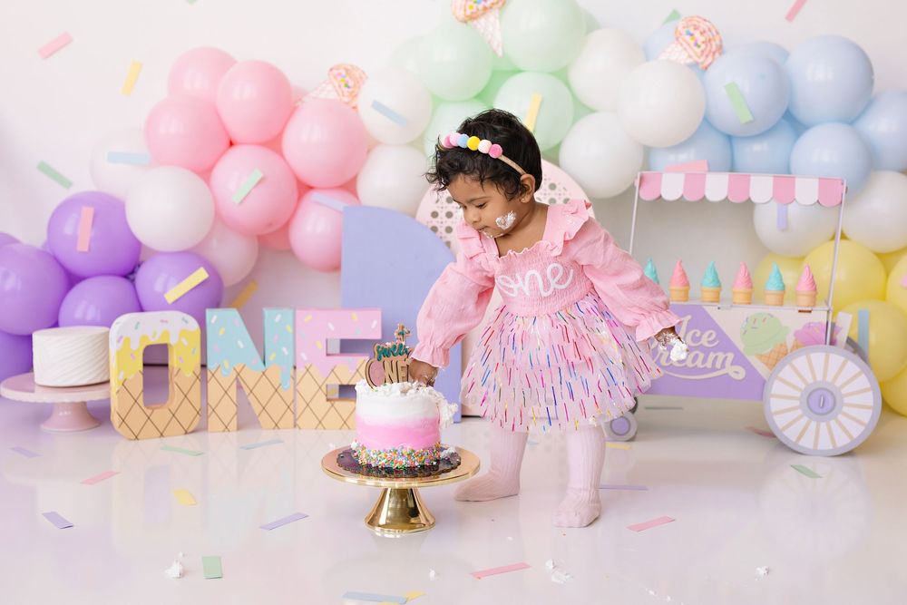 Pastel balloon arch displays with soft pink, blue and purple colors create a dreamy cake smash photography setup.  Kendall Kuss Photography
