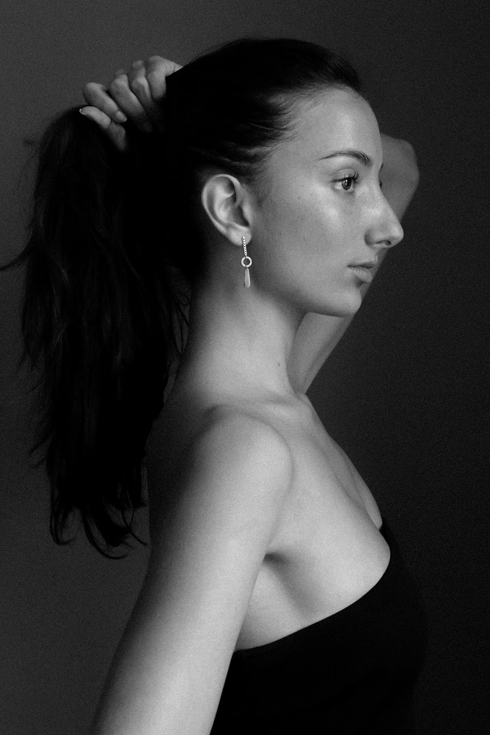 Elegant black and white profile portrait featuring a minimalist silver earring.