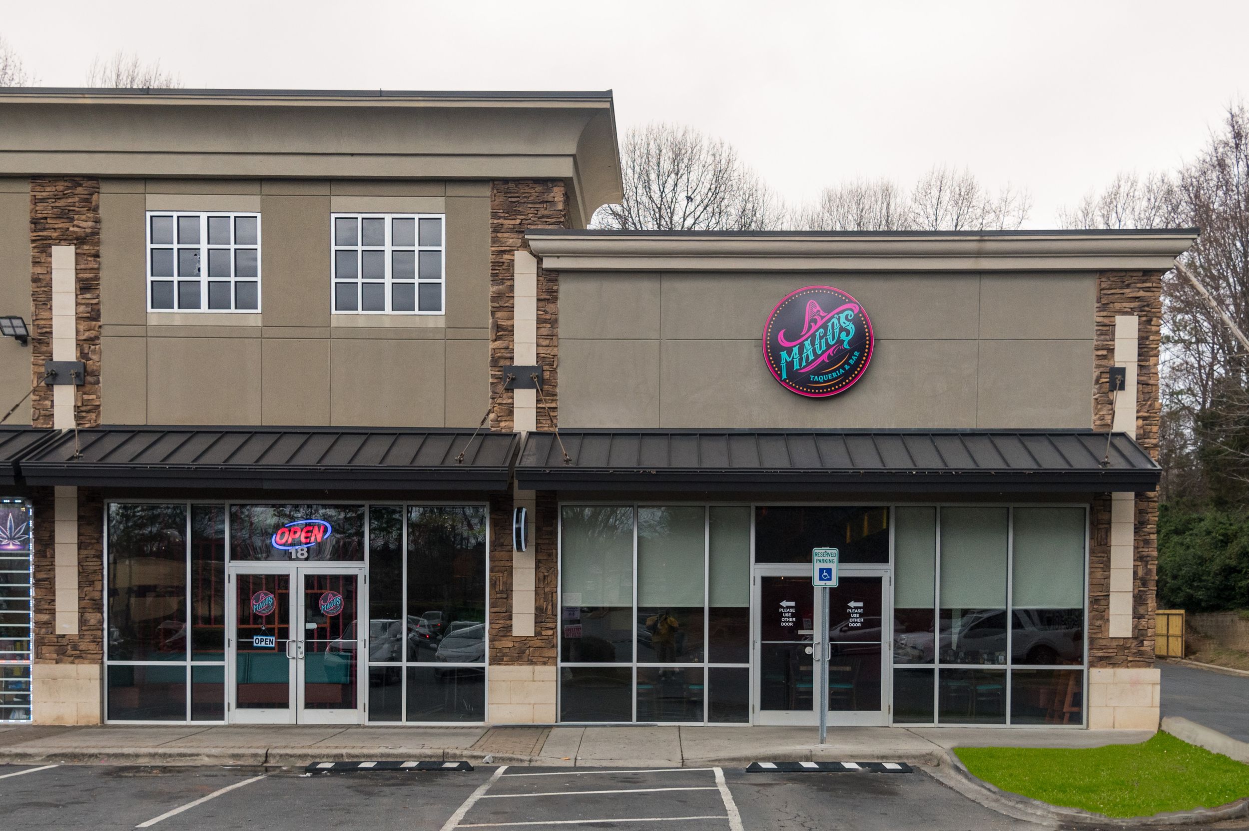 Exterior view of a Fusions restaurant in a strip mall with large windows and a dark awning.