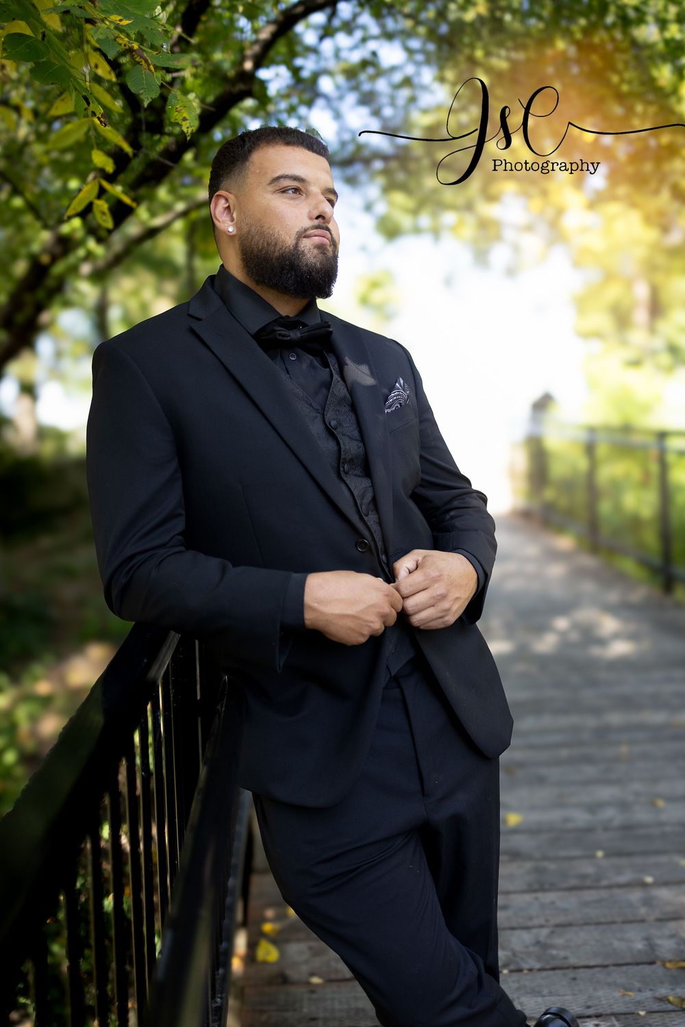 Outdoor formal portrait session in black suit against autumn foliage.