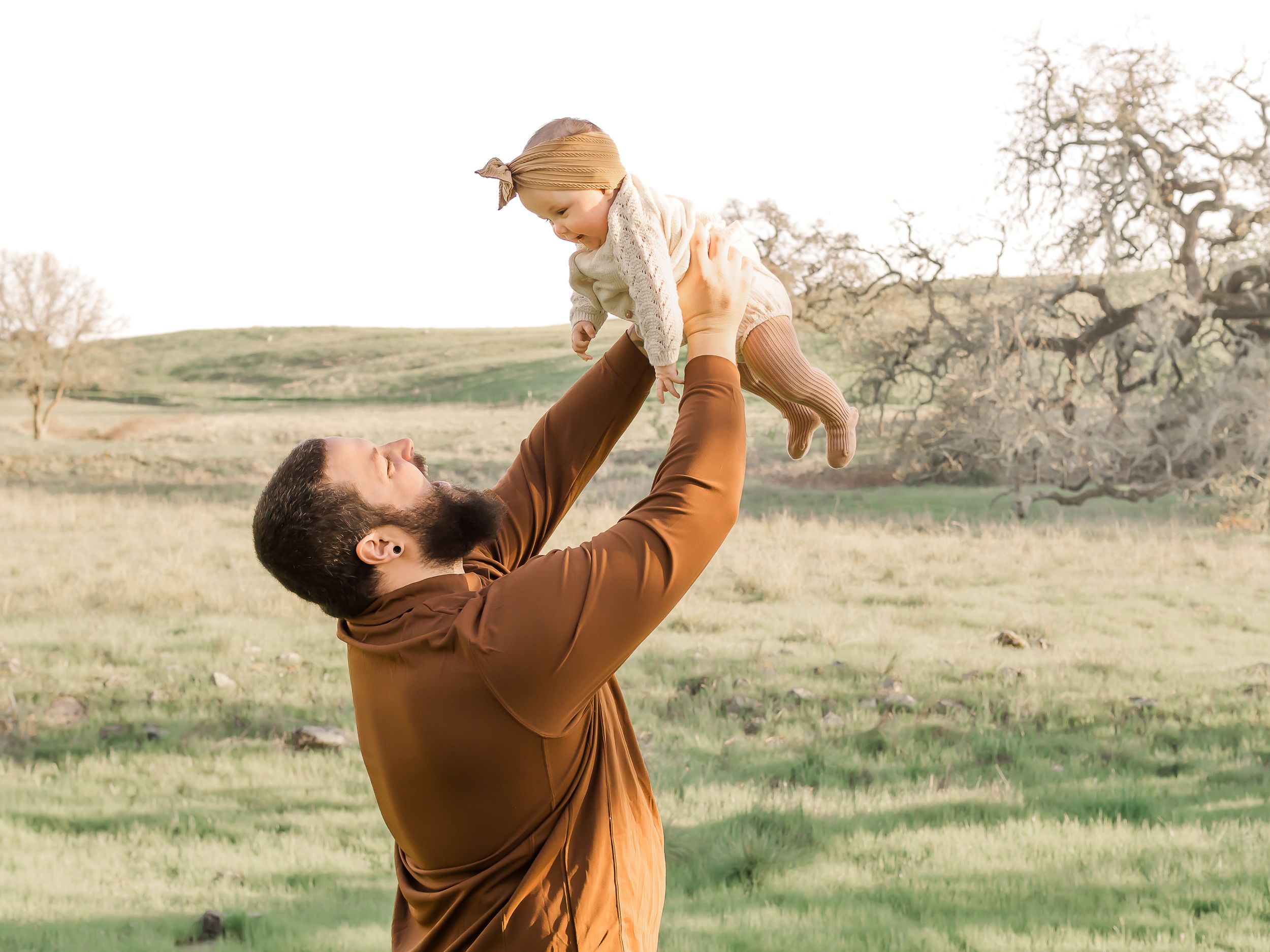 dad holding baby in the air at family photo session in Sonoma County California. kid friendly locations. newborn poses