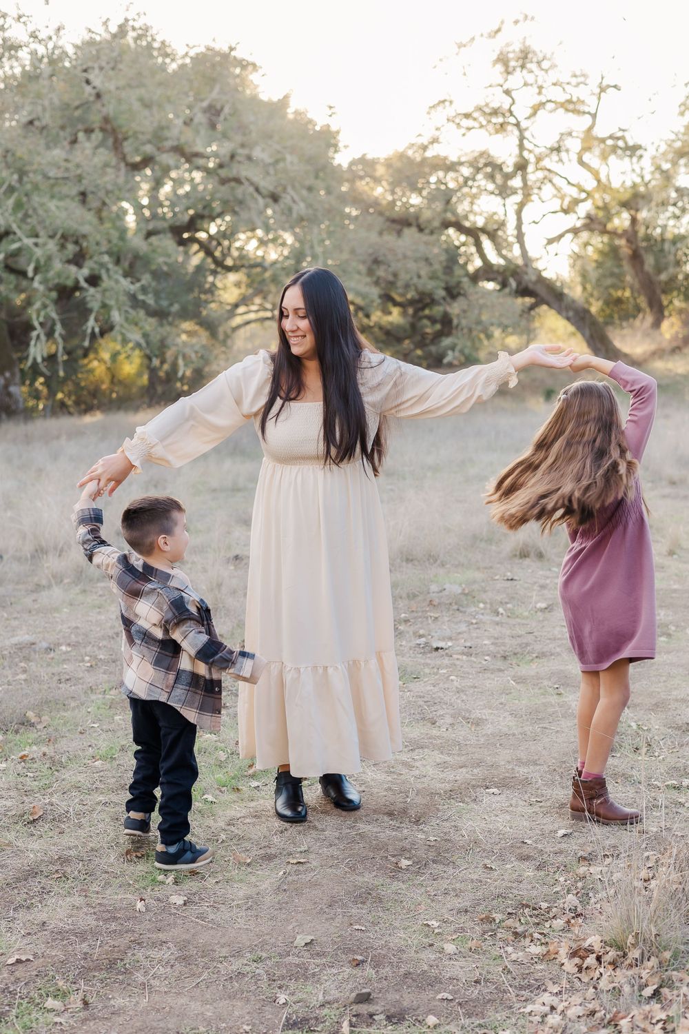 mom in dress twirling her two kids at sunset in Sonoma County California mini session