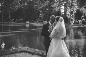 Black and white photo of a bride and groom sharing a romantic moment by the cooling pond at Papplewick Pumping Station.