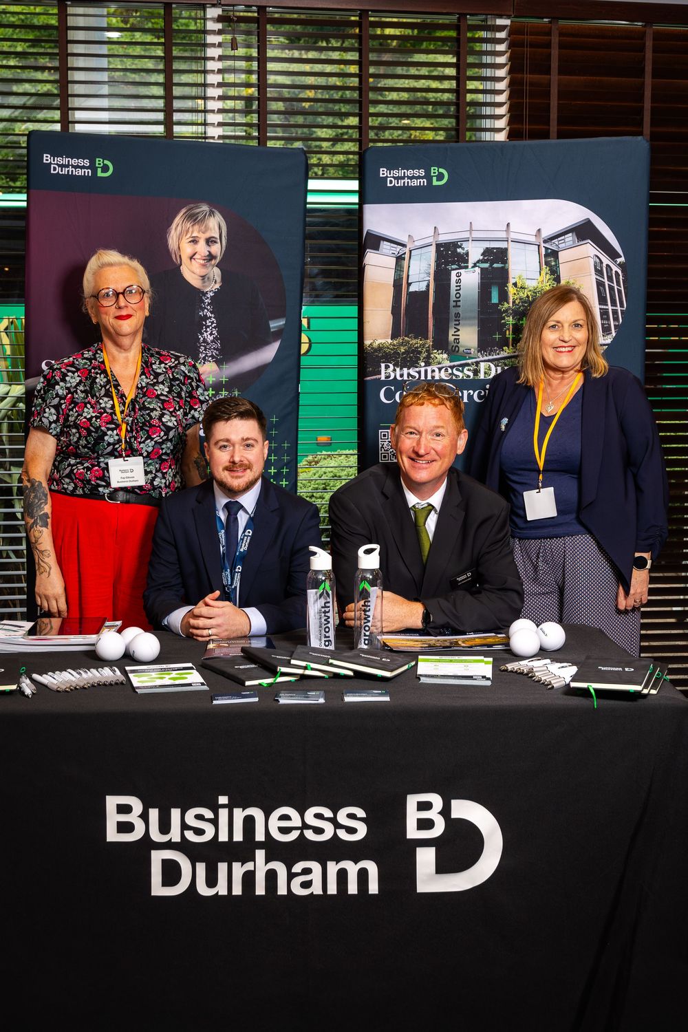 Business Durham team at an event stand, posed with branded materials and banners in a professional indoor setting.