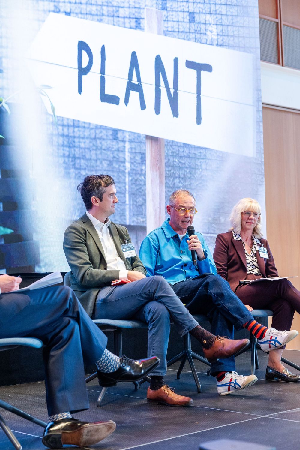 Panel speakers share insights on stage during a design-focused discussion at a professional event.