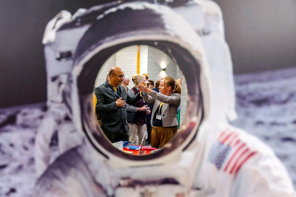 Corporate North East Space event, capturing delegates networking at a space industry conference, framed through an astronaut suit display.