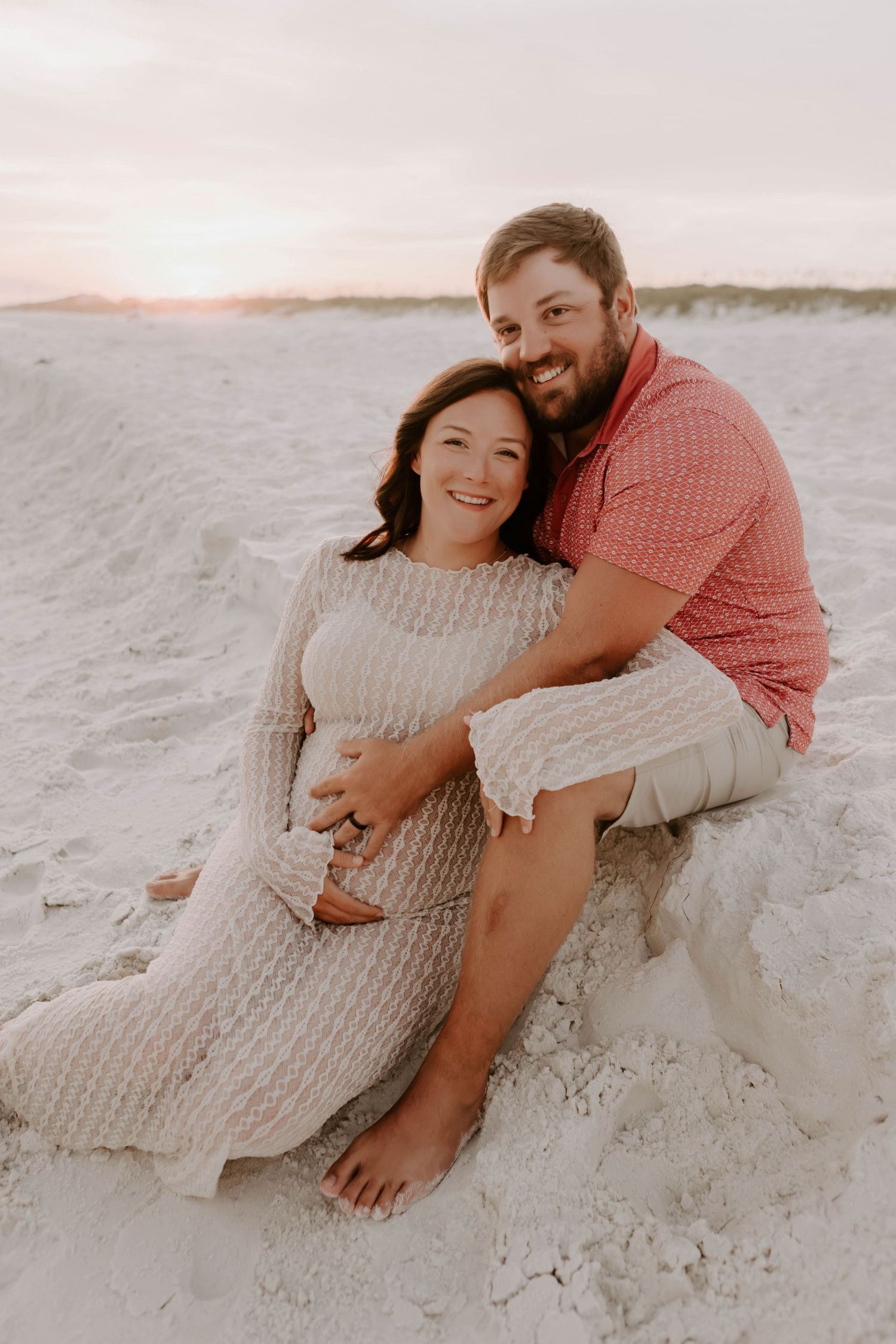 Maternity photo session, a couple lovingly smiling for the photo at sunset in Navarre, Florida