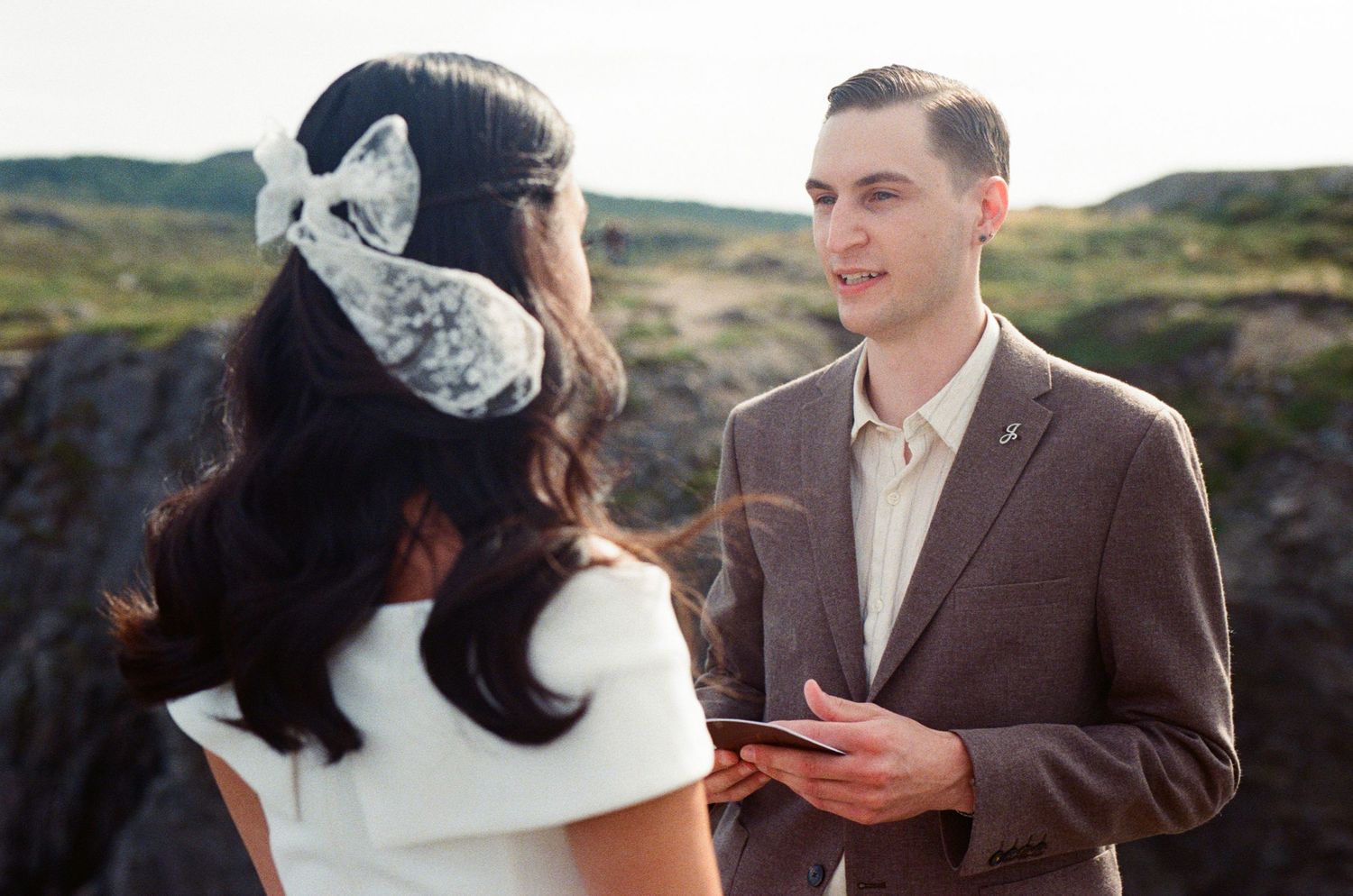 35 mm film photo of groom reading vows from book during elopement ceremony on vancouver island