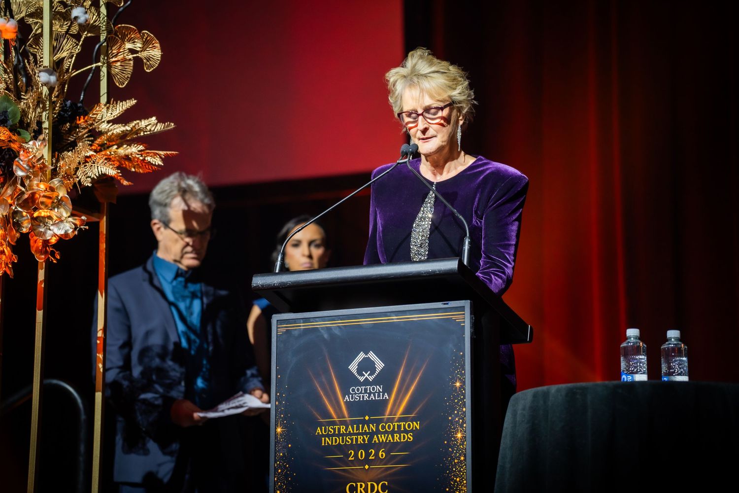 Woman in purple speaks at podium during Australian Culture Industry Awards 2018 ceremony on stage.