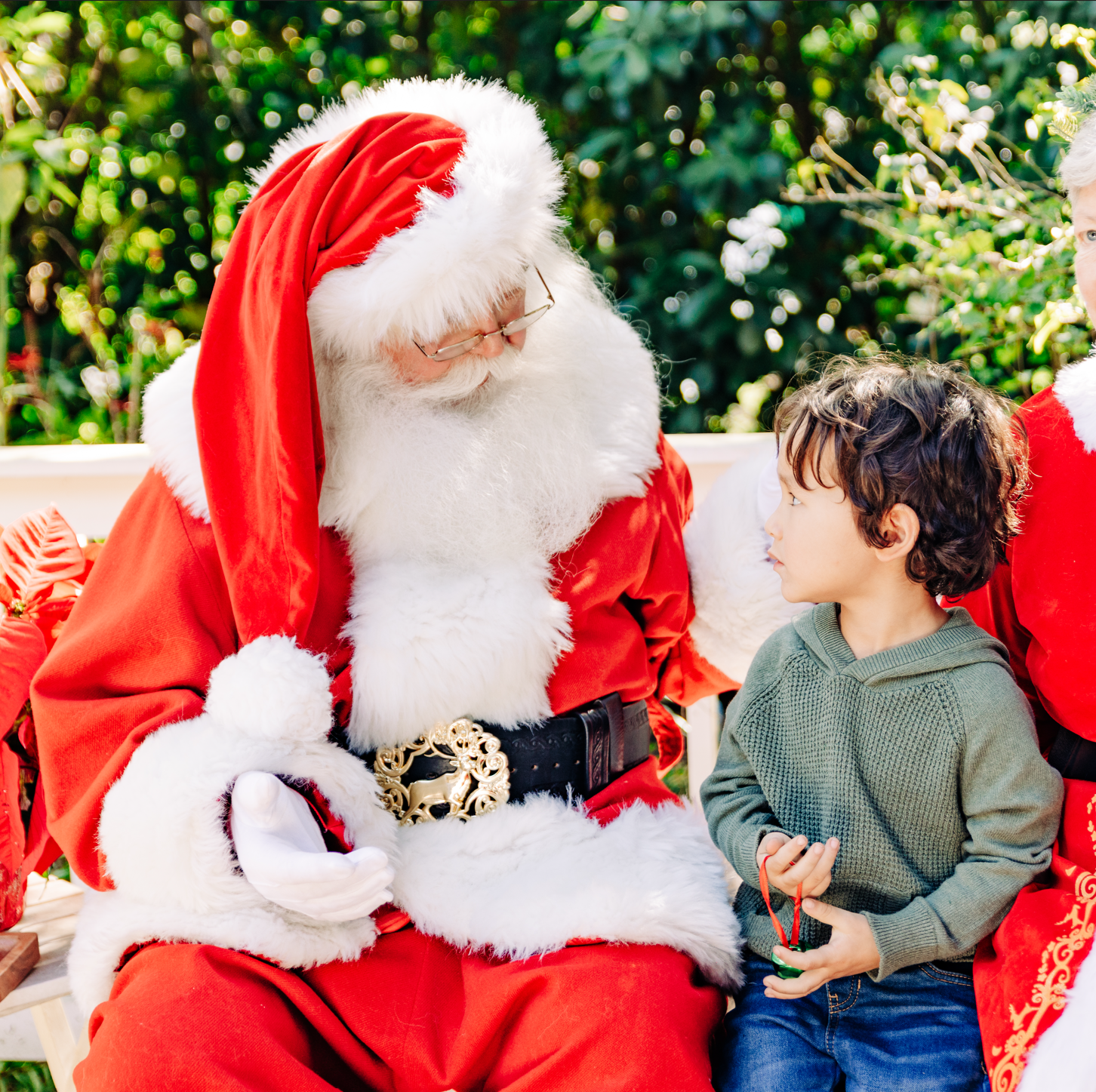 Santa photos in Lake Worth Beach with a young child talking with Santa Claus during a Christmas portrait session.
