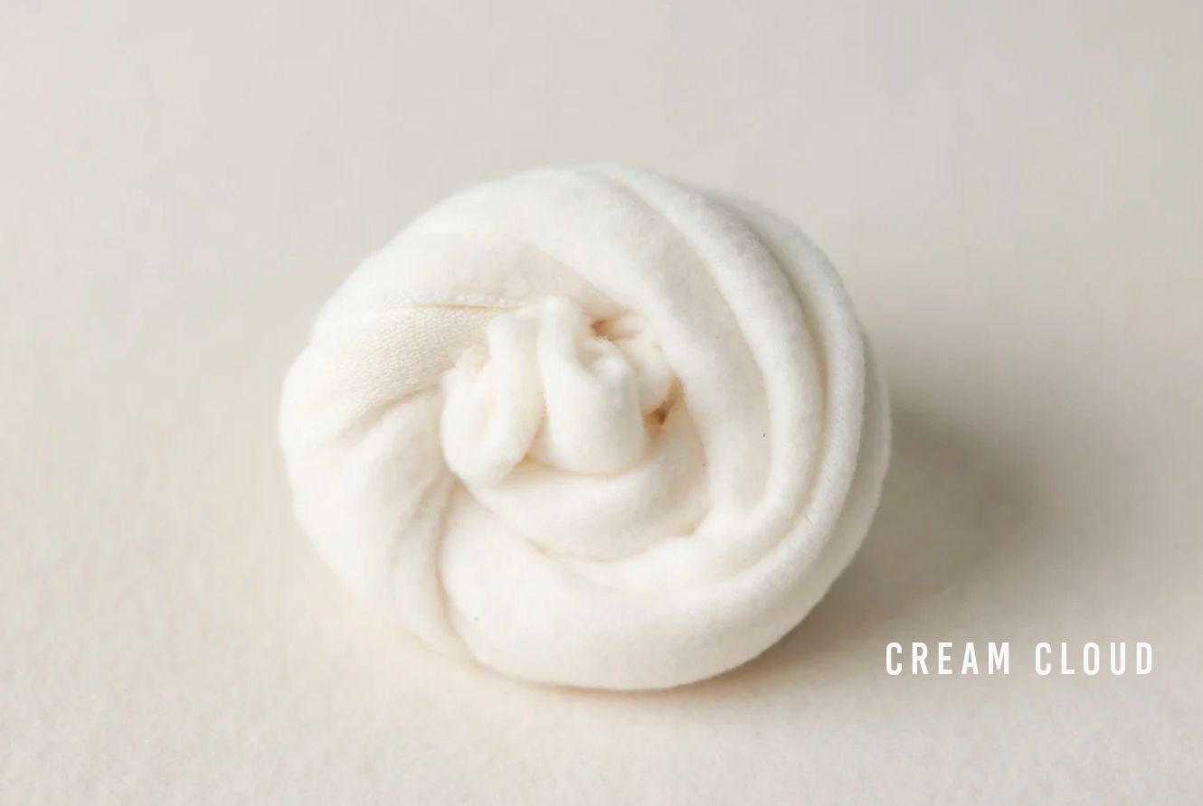 Cream Cloud fluffy white slime coiled into a rose shape on a neutral background.