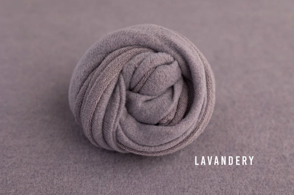 Lavender gray knit wrap coiled into a neat bundle, perfect for newborn photography props.