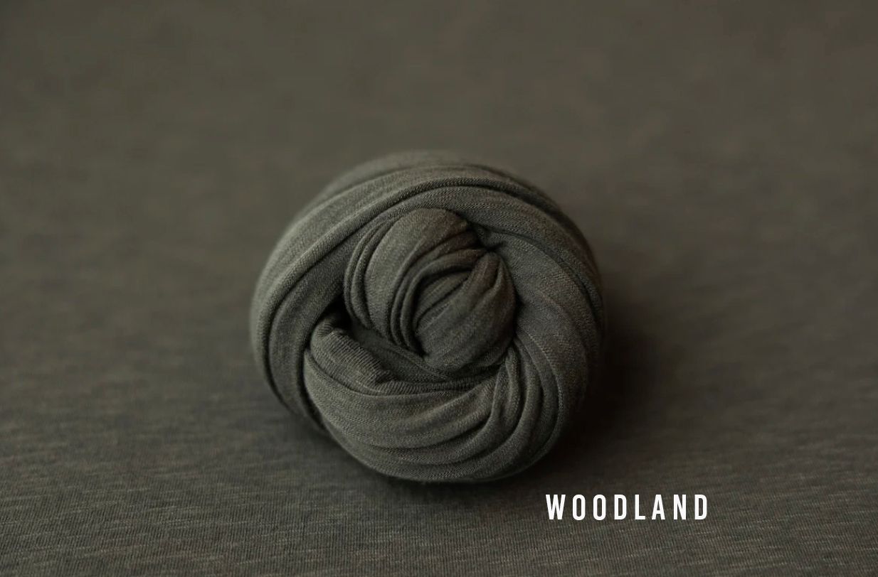 Woodland dark olive green knit wrap rolled into a coil for newborn photo props.