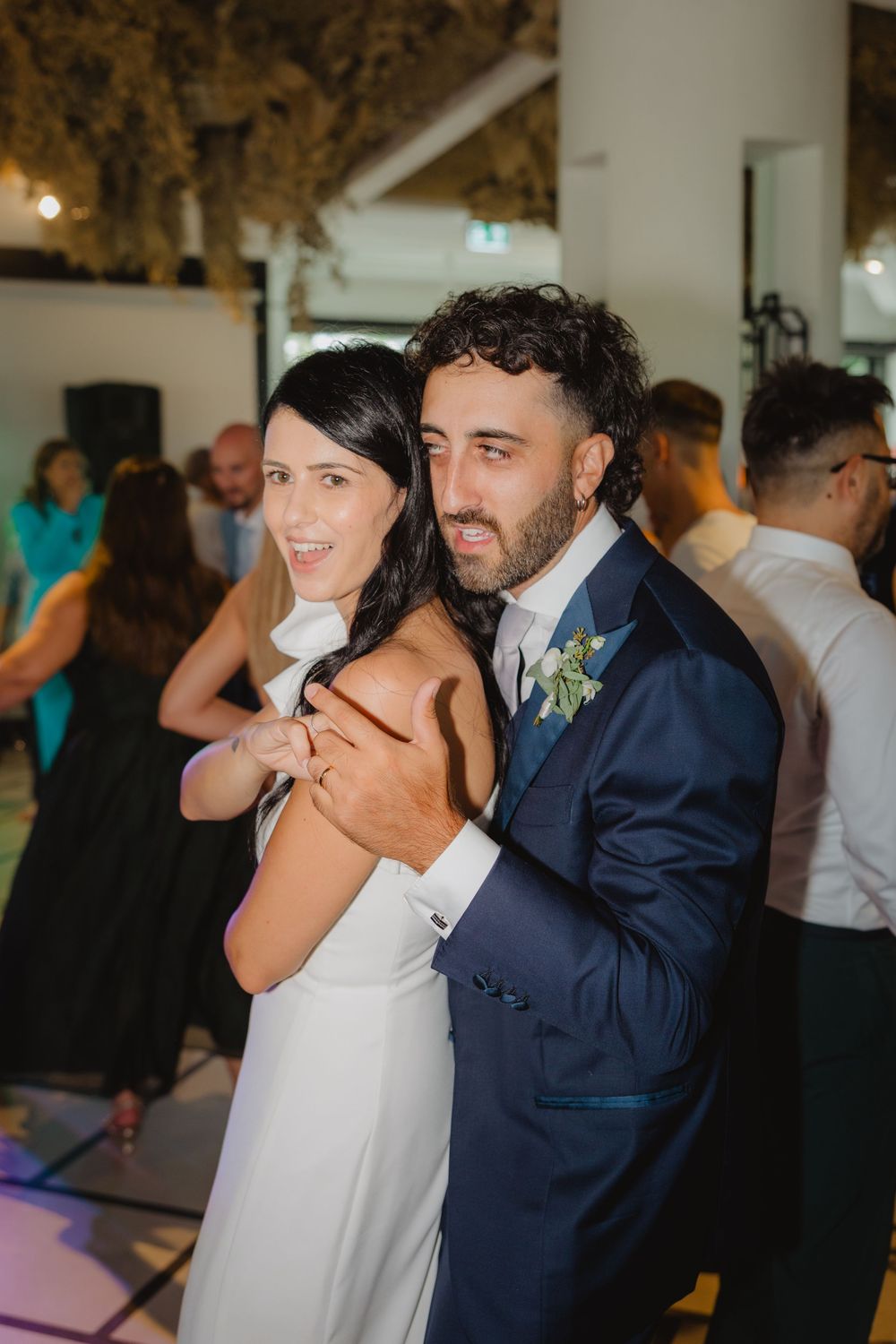 Lorenzo e Laura vicini, con le mani intrecciate durante la festa.