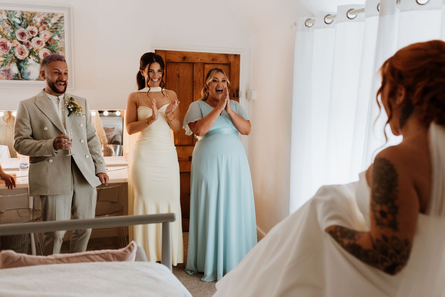 Bride reveals wedding dress to emotional family members, including a man in tan suit and woman in blue gown, at Stanford Farm, Shropshire