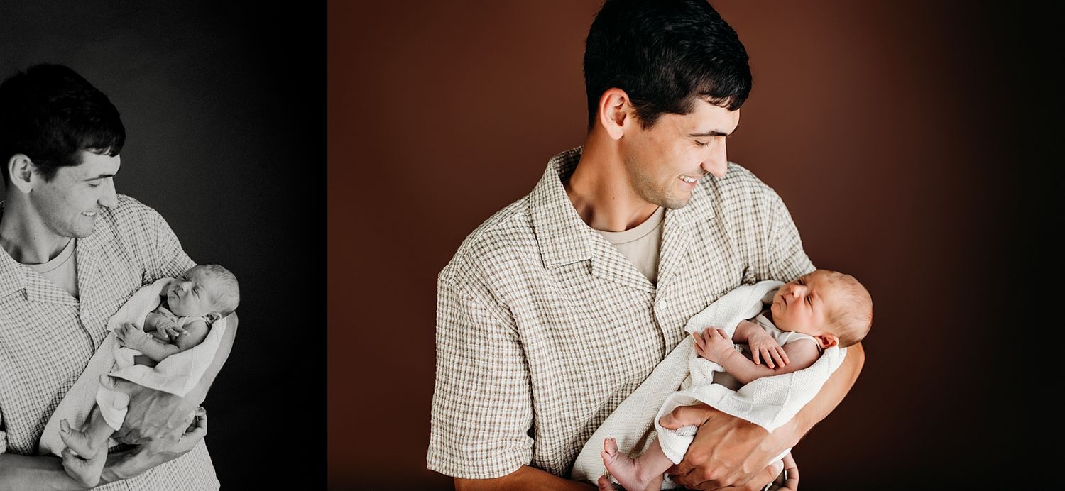 A father tenderly holds his newborn baby in a heartwarming studio portrait session.