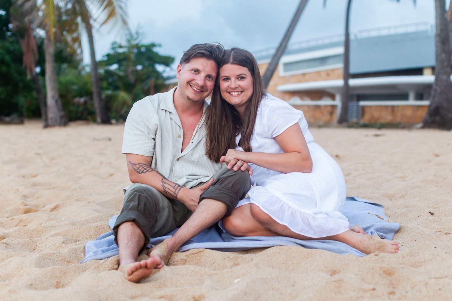 Couples portrait seated on the beach at Balneario del Escambrón in Old San Juan, Puerto Rico.