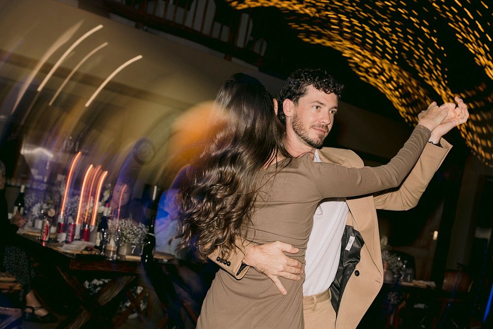 Elegant couple dancing closely together at a dimly lit evening reception.