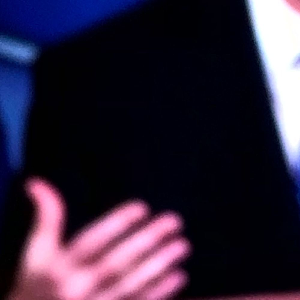 Close-up of an outstretched hand against a dark black background.