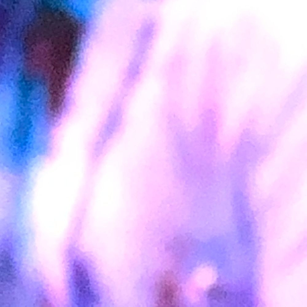 Abstract blurred purple and blue light bokeh background with soft glowing pink and white tones.