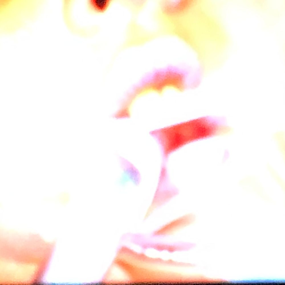 Abstract overexposed portrait with vivid red and white tones, showing a blurred face with an open mouth.