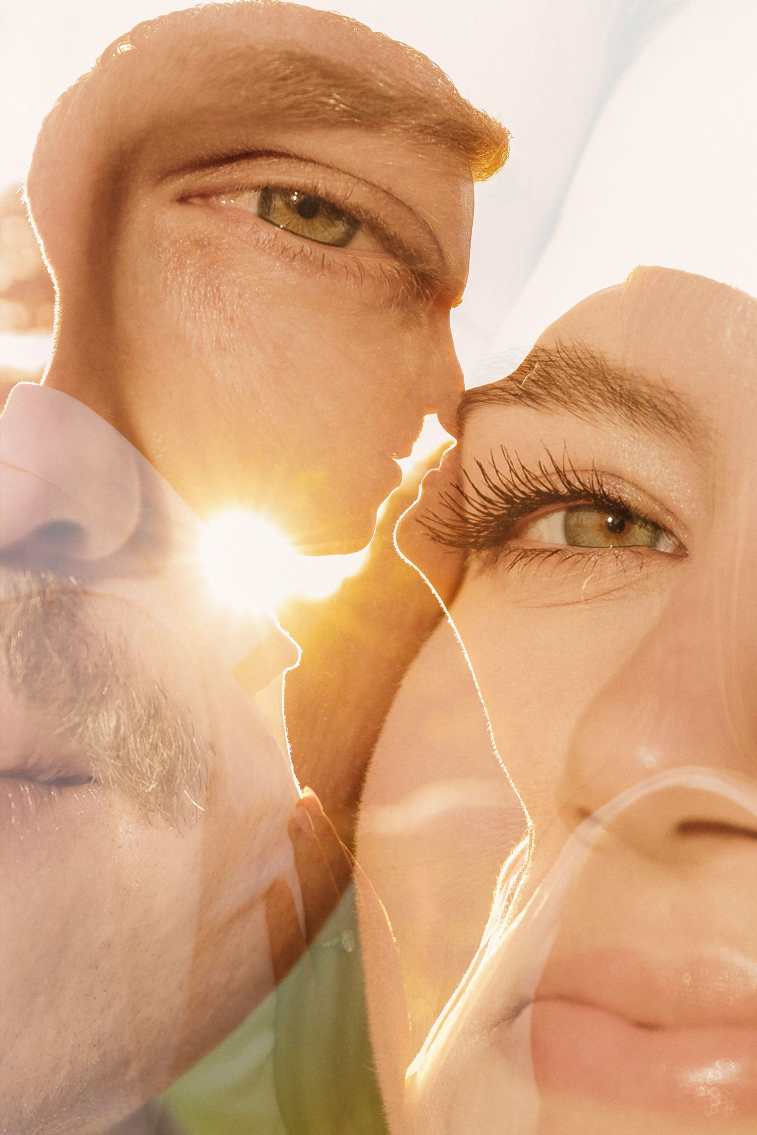 Double exposure portrait of a man and woman with green eyes, illuminated by warm golden sunlight.