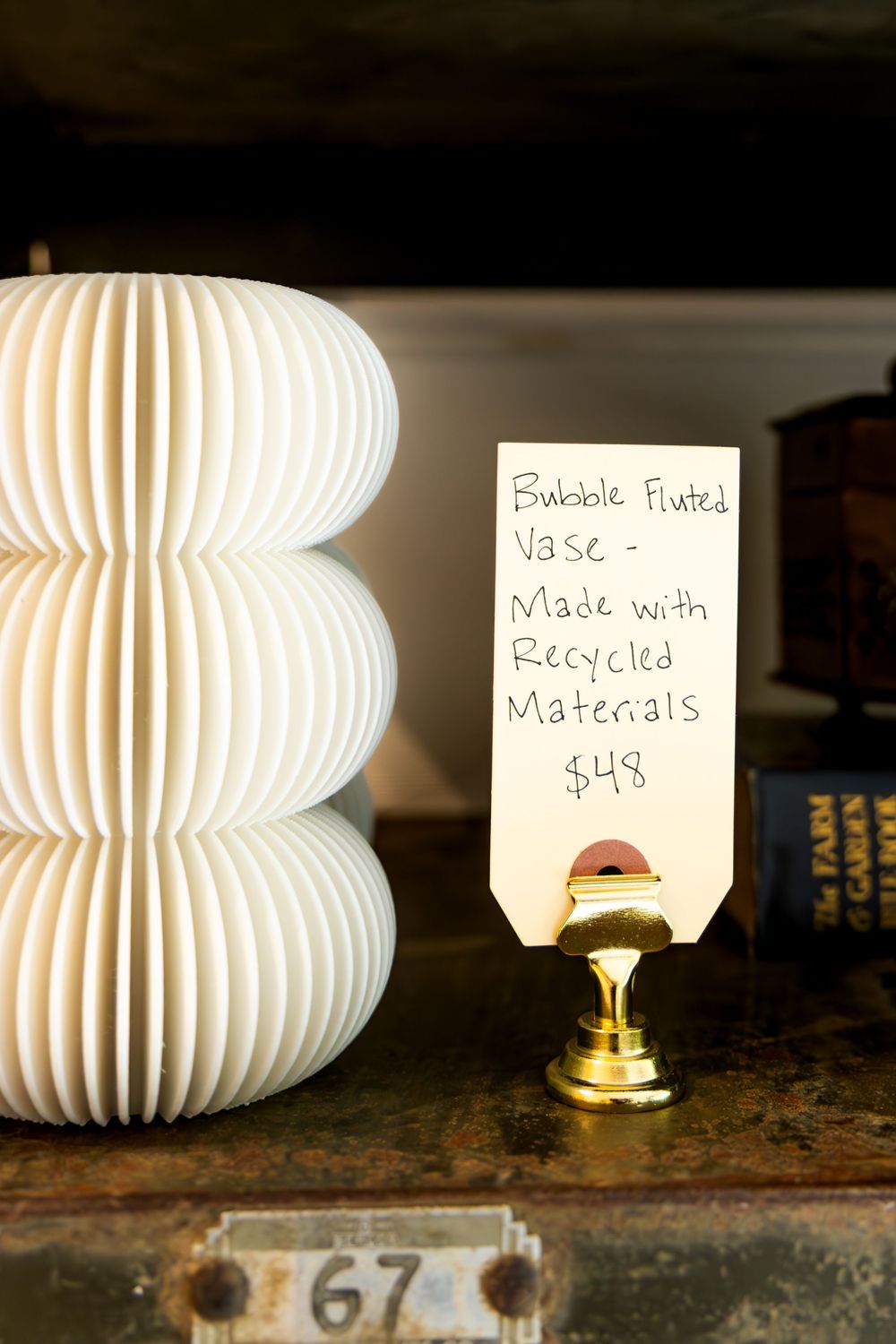 White bubble fluted vase made with recycled materials displayed on shelf with handwritten price tag reading $48. Swell House La Grange