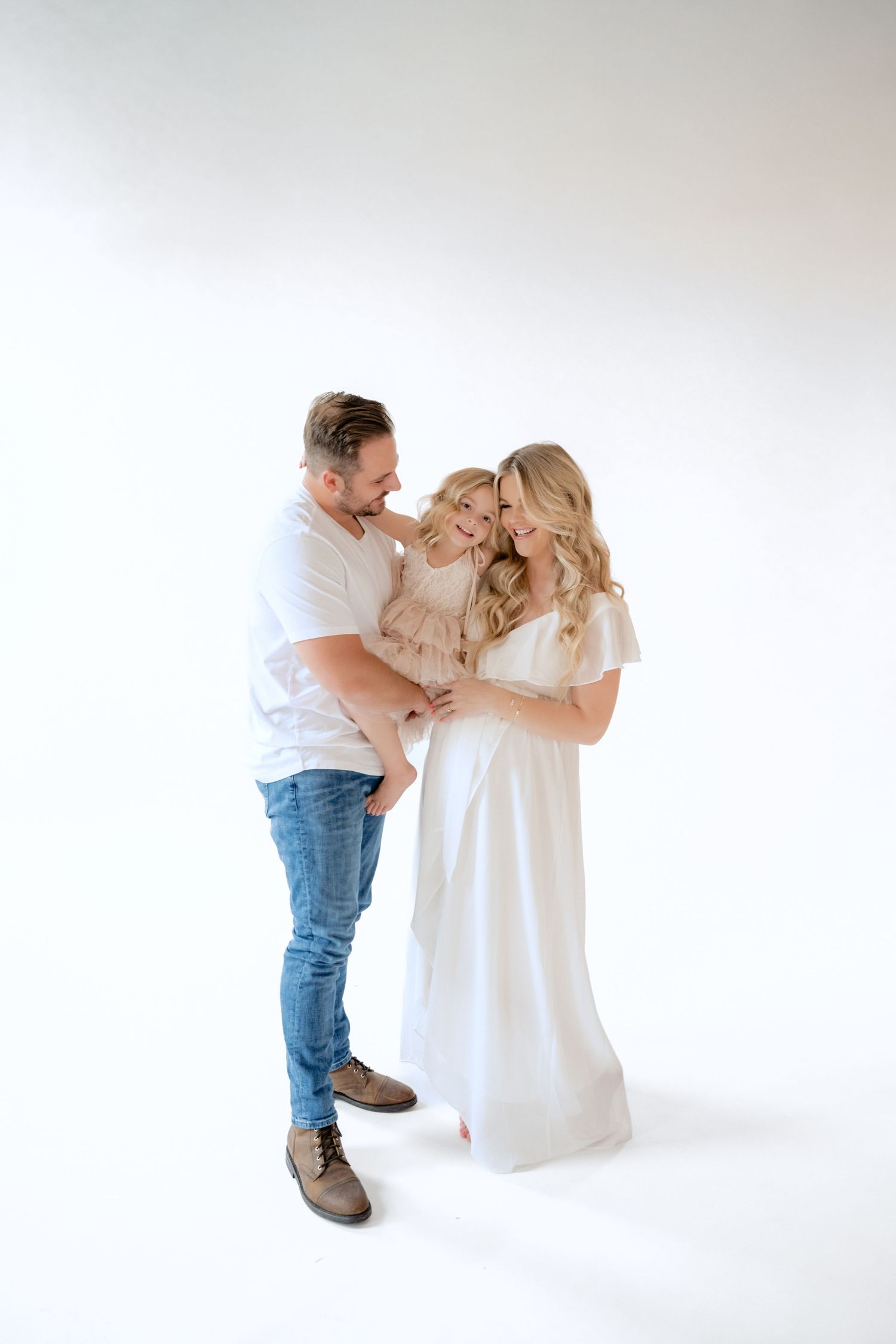 Family snuggles and laughs during in studio maternity session in stillwater mn portraits with jagger rose photography