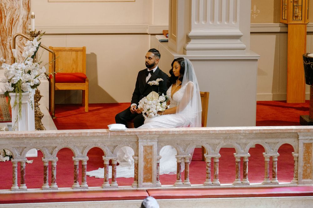 Bride and groom sit together at the altar during their elegant church wedding ceremony.