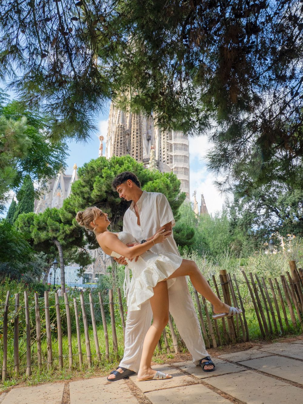 Couple dancing a romantic dip in front of Sagrada Familia basilica in Barcelona, Spain.