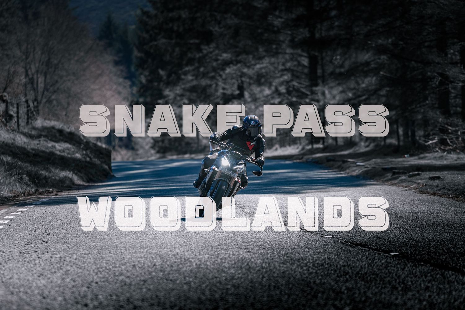 A motorcyclist rides a Monyash B5055 bike on a rural country road with another rider visible in the distance.