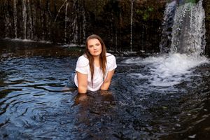 A series of photos showing someone playing and splashing in a waterfall on a sunny day.