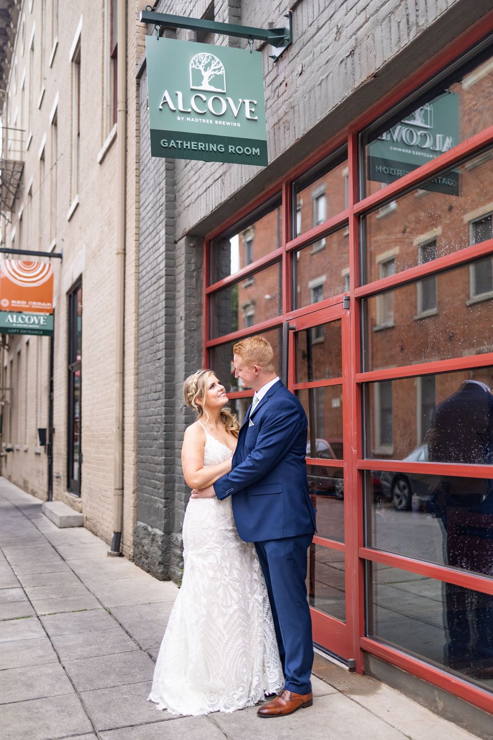 Bride and groom embrace outside the Alcove Cincinnati wedding venue on their wedding day.